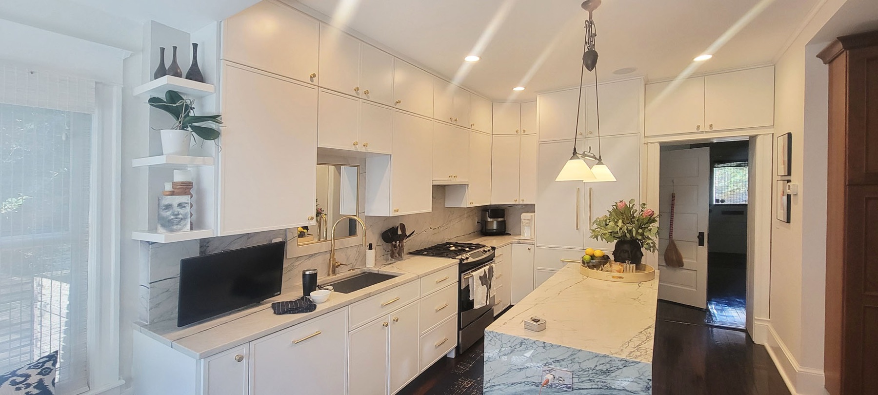 A Pro Refinish refaced kitchen: white Shaker doors, brass hardware, marble island